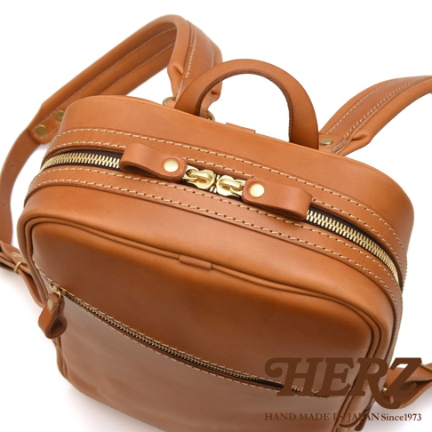 職人手作皮革長方型多口袋後背包，經典棕色，採用厚實皮革製作，配有金色雙拉鍊開口，多個外層口袋設計，車縫線明顯，質感優良。