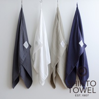 四條懸掛的2.5層紗浴巾，顏色分別為炭灰色、白色、卡其色和海軍藍，材質輕柔，表面有細緻紋理。