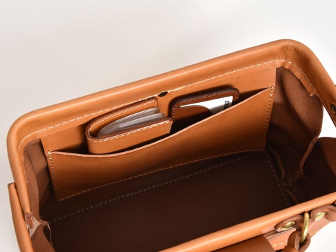 職人手作皮革兩用迷你口金單肩包 (CW-7) 的內部，展示了淺棕色皮革，包含卡片夾層，其中置放了卡片和名片。