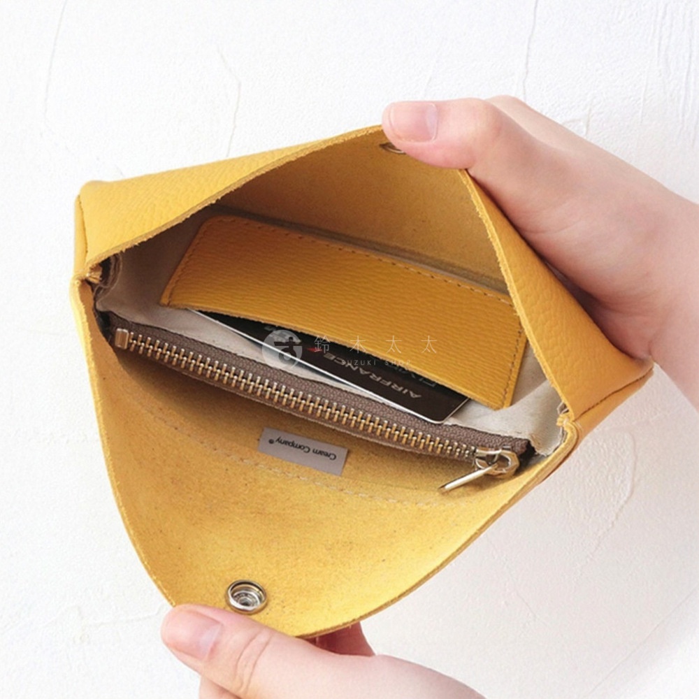 黃色皮革手拿包，內有拉鍊夾層，可放置卡片。包款採用柔軟皮革材質，邊緣有品牌標誌。