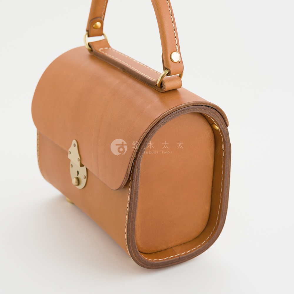 棕褐色皮革復古杜勒斯手提包，圓筒狀包身，配有頂部提把、金色旋轉鎖扣和白色縫線。