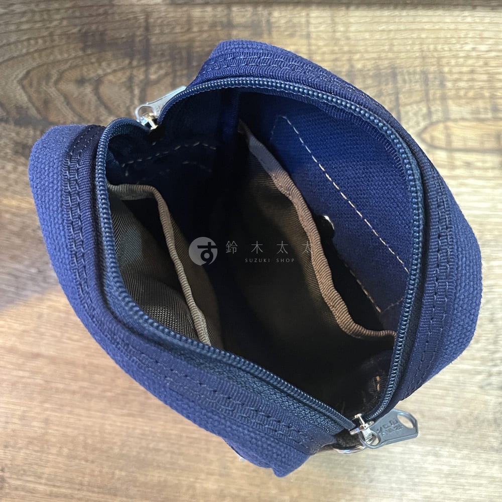 石洗帆布斜背手機包，深藍色，外觀為帆布材質，內部有分隔層，拉鍊設計，展示包包開啟狀態。