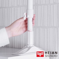 白色伸縮防傾桿，頂部設有可調節旋鈕，底部為寬闊的底座，由塑膠製成，用於支撐和固定。