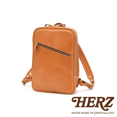 職人手作皮革長方型多口袋後背包，採用天然皮革材質，呈現溫潤的棕褐色，設有斜向拉鍊前袋、頂部提把及可調節式皮革背帶，風格簡約實用。