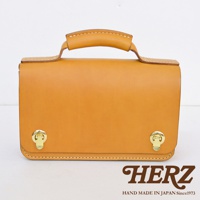 職人手作皮革經典兩用雙扣迷你單肩包，呈現自然色澤皮革，配有金色雙鎖扣及提把，簡約設計。