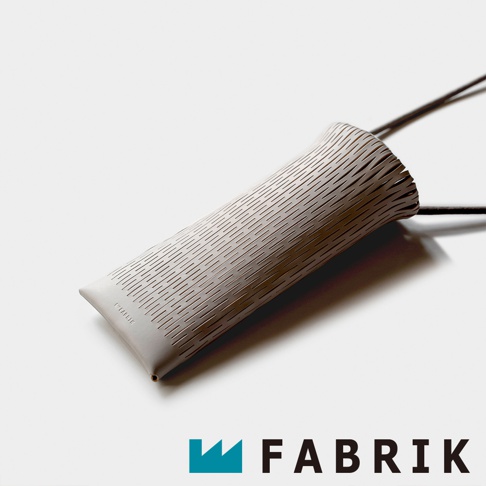FABRIK 品牌標誌旁是一個淺灰色的皮革隨形貼合伸縮小包，包身佈滿細密的斜線紋路，底部印有品牌名稱