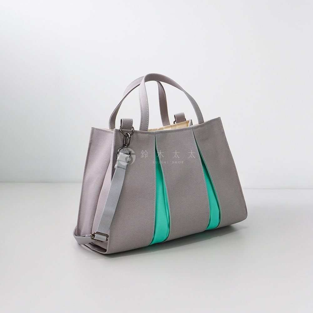 京都職人手作ougi棉帆布兩用扇形托特包，以淺灰色為主體，搭配中間的翠綠色布料，扇形褶皺設計，配有短提把和可拆卸的長肩帶，整體風格簡潔俐落。