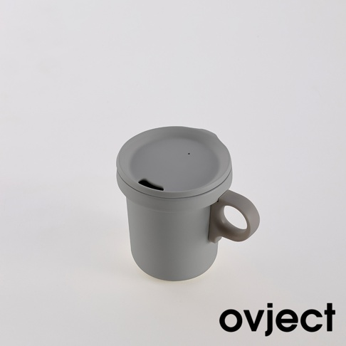 灰色琺瑯馬克杯，帶有同色系杯蓋和提把，杯蓋上設有飲用孔。