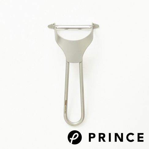 銀色金屬削皮器，刀片為不銹鋼材質，握柄為一體成型設計，上面印有「PRINCE made in Japan」字樣。