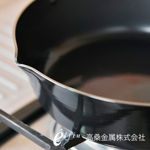 日製 24cm 雙耳鍛鐵炸鍋，鍋身為黑色，帶有銀色鍋緣，放置於爐架上。