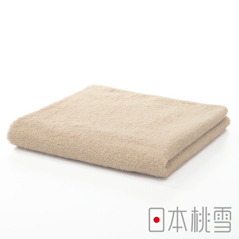 一張米色精梳棉飯店毛巾，材質柔軟，表面有細緻的絨毛，毛巾對折後平鋪於白色背景上，右下角有日文品牌標誌。