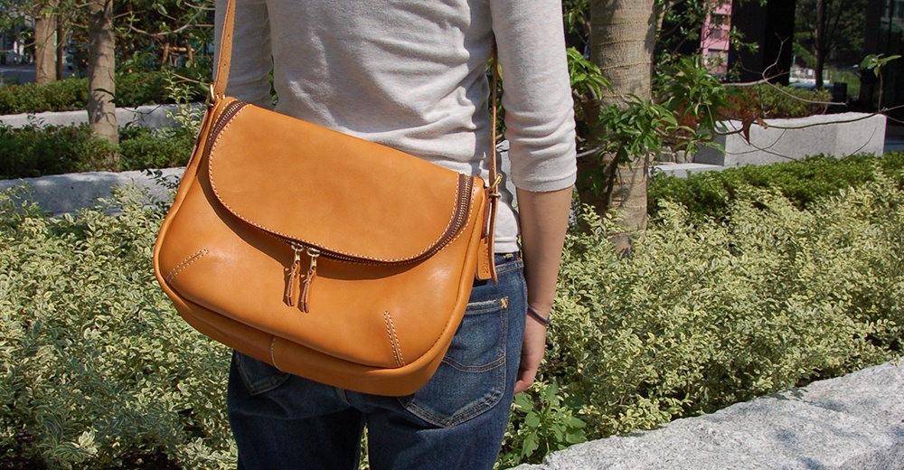 日本HERZ職人手作Stare皮革大容量馬鞍包，採用鞣製皮革製成，具備簡約風格的雙拉鍊開口設計。