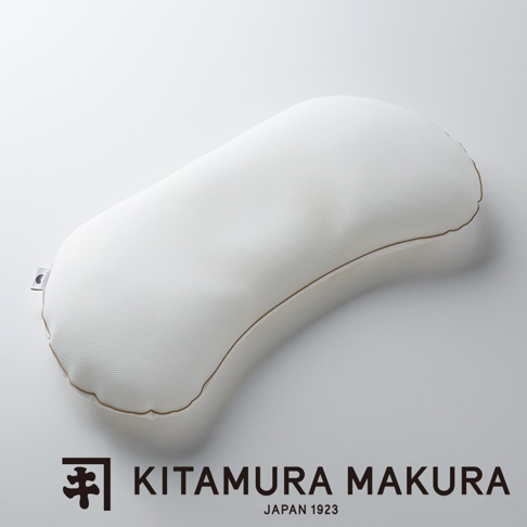 白色網狀布料的彎月形枕頭，邊緣有細緻的咖啡色滾邊，枕頭表面有細小的格子紋理。