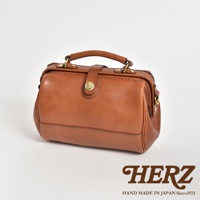 一個棕褐色的皮革醫生包，採用復古口金設計，配有頂部提把和可拆卸肩帶。包身線條簡潔，縫線工整，金色金屬配件增添質感。