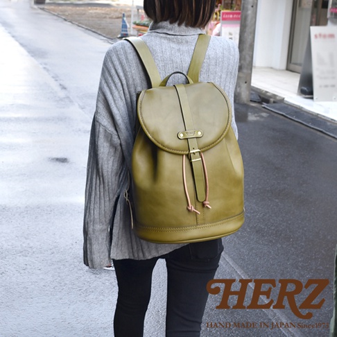 職人手作皮革單扣束口後背包，橄欖綠色，單扣翻蓋設計，附有束口繩。