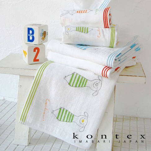 白色嬰兒毯，繡有綠色條紋的可愛動物圖案，邊緣有綠色條紋。另有滾邊為紅色或藍色的同款嬰兒毯堆疊。