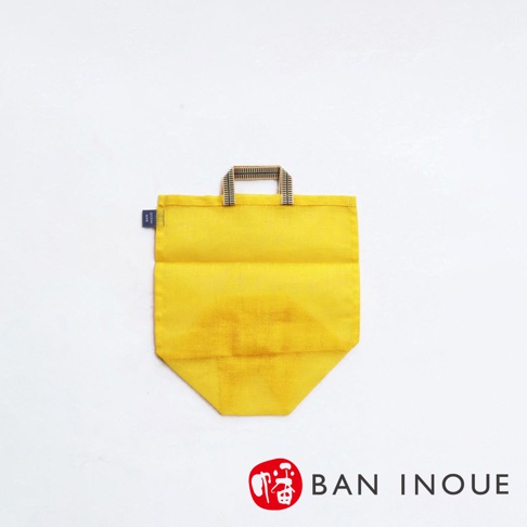 黃色提把蔬果收納袋，材質為透氣網布，尺寸為 M，袋身有皺褶紋理，上方有織紋提把，左側有品牌標籤。