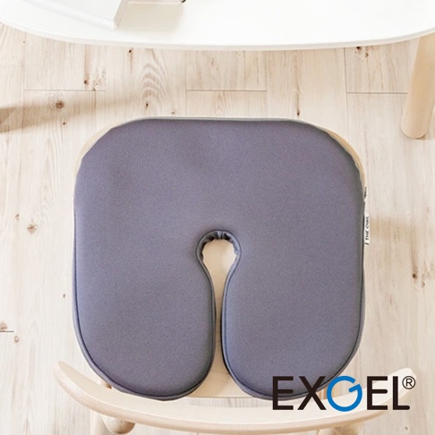 THE OWL Standard U貓頭鷹U字型坐墊，採用灰色布料製成，坐墊中央有U型開口，邊緣為淺木色滾邊，放置於木質椅子上。