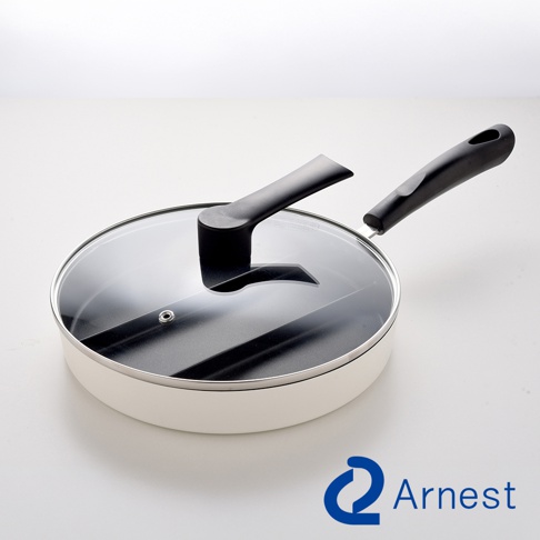 一個採用白色鍋身與黑色不沾塗層的Arnest品牌三合一分格平底鍋，鍋內設計有三格分隔板，配有專屬透明玻璃蓋，鍋蓋中央設有黑色把手，整體搭配長柄設計，放置在純白背景中呈現。