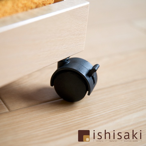 淺色木質收納推車的黑色萬向輪特寫，輪子上帶有鎖定桿。