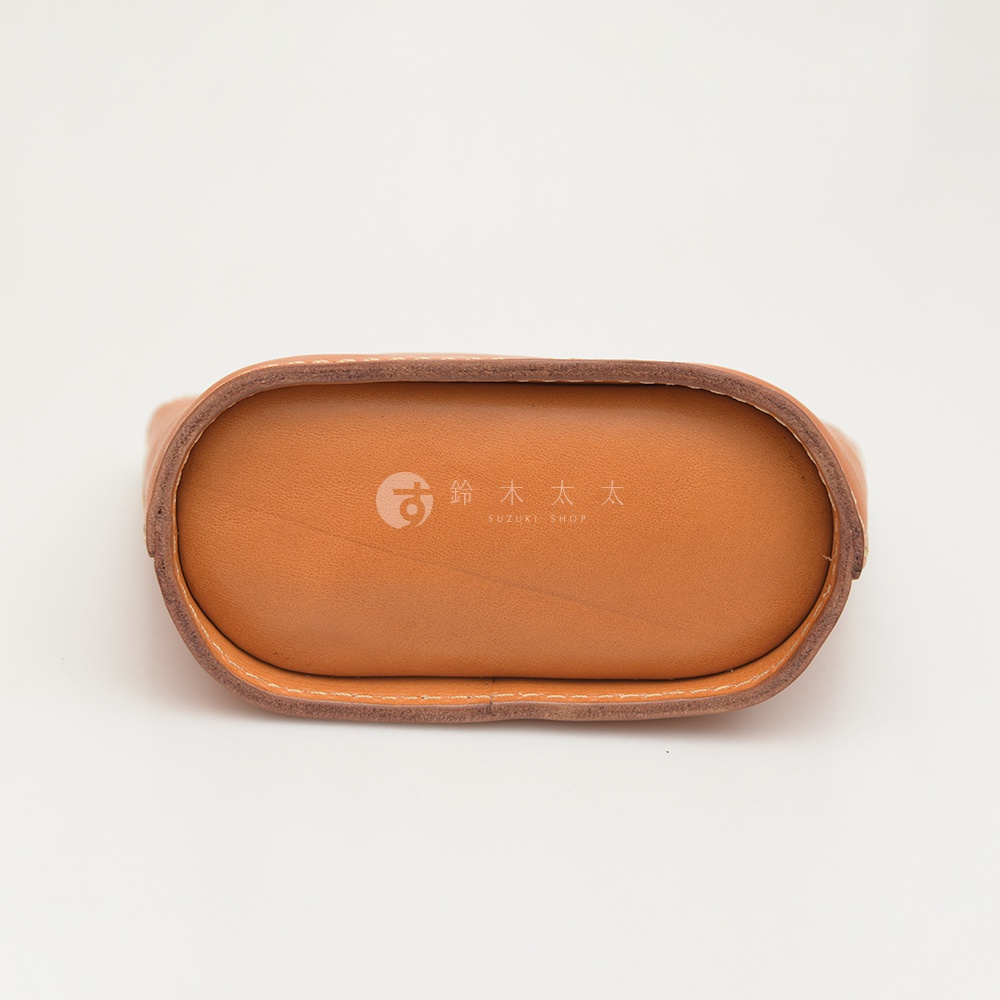 棕色皮革三角收納包，底部壓印有「鈴木太太」及「SUZUKI SHOP」商標。