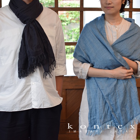 深藍色羊毛棉質混紡絲巾，帶有流蘇邊飾，由男性模特佩戴。淺藍色羊毛棉質混紡絲巾，帶有流蘇邊飾，由女性模特佩戴。