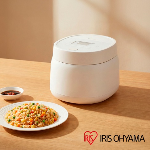 圖中為一個白色電子鍋，旁邊擺放著一盤炒飯和一小碟醬料，右下角有 IRIS OHYAMA 的品牌標誌。