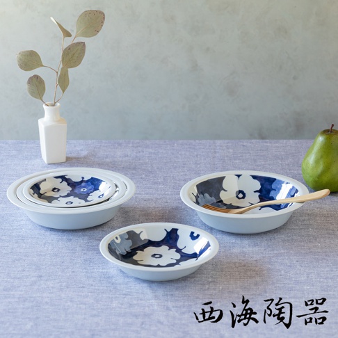 波佐見燒藍花紋四件式深碟盤組，包含大小不同的三個碟盤，皆為白色陶瓷，內側印有藍色與白色的花卉圖案。其中一個碟盤內放有木製叉子。