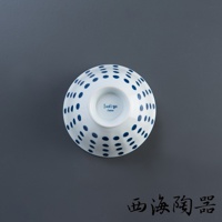 白色陶瓷飯碗，碗身外觀佈滿藍色圓點紋飾，碗底中央有「Indigo Japan」字樣。