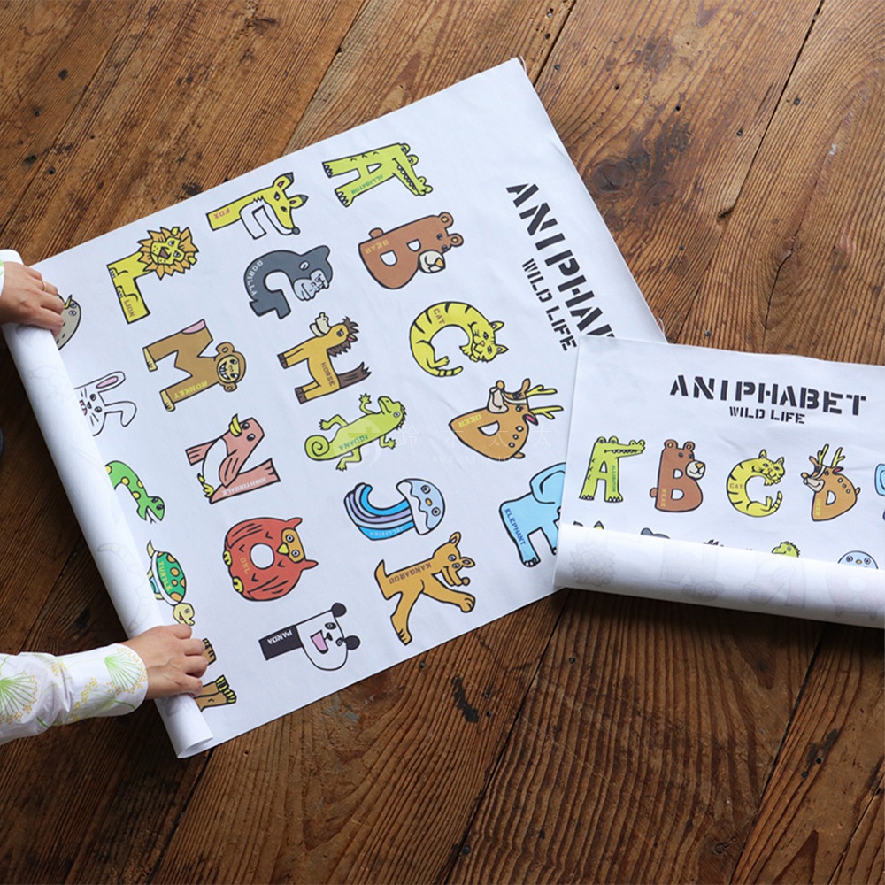 無框帆布藝術海報，印有「ANIPHABET WILD LIFE」字樣，以鮮豔色彩繪製了字母與動物圖案，例如字母A搭配鱷魚、B搭配熊、C搭配貓等，整體為白色帆布材質，呈現豐富的動物夥伴插畫。