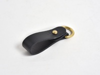 黑色皮革吊掛扣帶，搭配黃銅色金屬環和鉚釘。