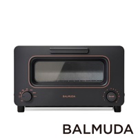 黑色蒸氣烤麵包機，設有銅色邊框，上方有提把，正面有長方形玻璃視窗，下方有兩個旋鈕，左側旋鈕標示溫度，右側旋鈕標示時間。