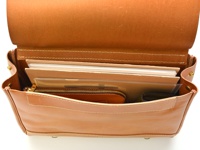 職人手作皮革屋瓦風兩用側背包，經典棕色，光滑皮革材質。包內可見多層隔層，整齊收納著筆記本、文件夾、拉鍊小錢包和卡夾，展現優雅實用的設計。