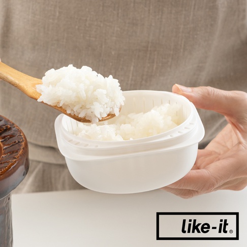 白色簡約雙層蒸氣循環保鮮盒，搭配木製飯勺盛裝著米飯，盒蓋有細密透氣孔。