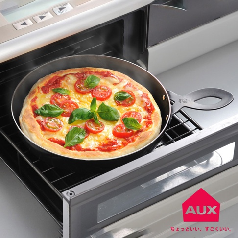 leye 披薩小鐵鍋內放著剛出爐的瑪格麗特披薩，披薩表面有融化的起司、番茄和羅勒葉，小鐵鍋為黑色，帶有長柄，整體置於烤箱架上。