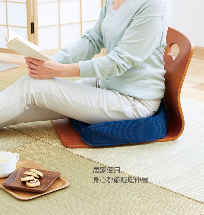 深藍色布面坐墊搭配木製椅背，有人坐著閱讀，坐墊置於榻榻米上。