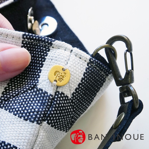 BAN INOUE 標誌、金色小圓牌、金屬掛鉤和斑馬紋布料細節。