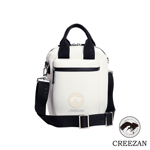 白色方形高爾夫側背包，帶有黑色提把、可拆卸肩帶和拉鍊前袋。包身飾有圓形壓印 Logo 及品牌名稱。