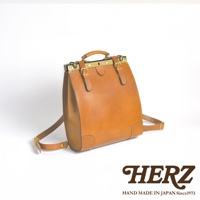 棕色皮革復古口金後背包，配有金色金屬扣環和可調式肩帶，上方有提把。