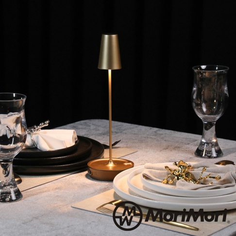 金屬復古氛圍燈，燈罩呈圓錐狀，燈身細長，底座為圓形。燈身及燈罩為金色，整體散發溫暖光芒。