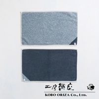 兩條棉麻混紡快乾浴墊，上方為淺藍色，下方為深藍色，皆有白色包邊及角落的品牌標籤。