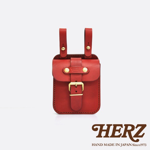 紅色皮革製成的經典腰袋，有兩個皮帶扣環及一個可調節的皮帶扣，袋蓋上有品牌標誌，整體呈現簡約復古風格。