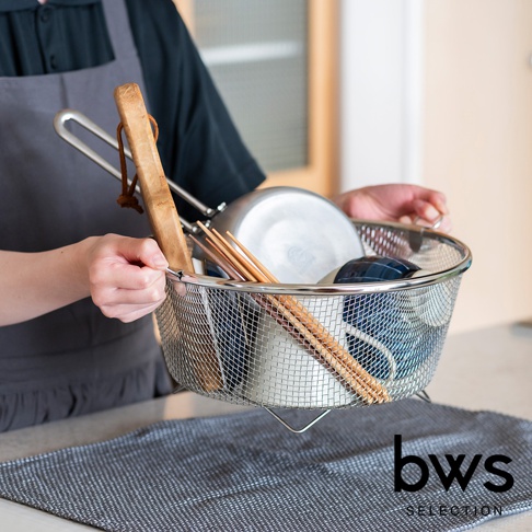 一個裝有碗盤和筷子的不鏽鋼圓形網狀瀝水籃，籃子帶有提把，由細密的銀色金屬網製成，底部有支架。