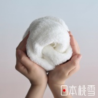 一雙手捧著一團蓬鬆柔軟的白色毛巾，右下角有日本桃雪的標誌和文字。