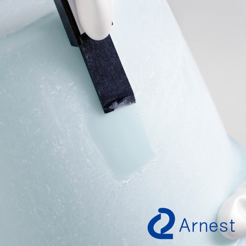 黑色刮刀頭正在清潔淺藍色、表面帶有紋理的圓柱形物體，刮刀頭的邊緣有白色殘留物。