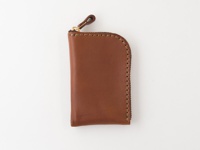 職人手作皮革迷你錢包，採用棕色皮革，配有金色拉鍊與皮革拉頭，車縫線為深棕色。