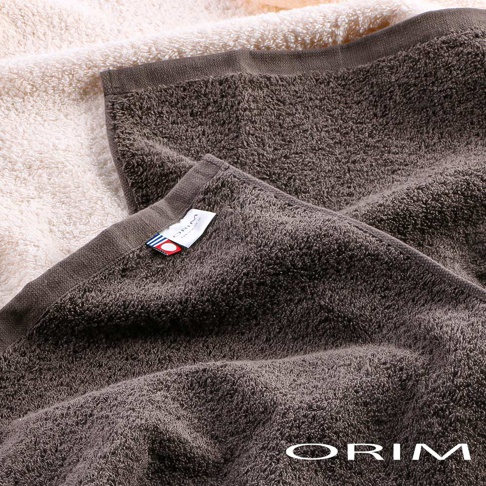 深棕色BULKY PRO今治沙龍毛巾，材質蓬鬆，觸感柔軟，帶有品牌標籤，下方另有一條淺米色毛巾。