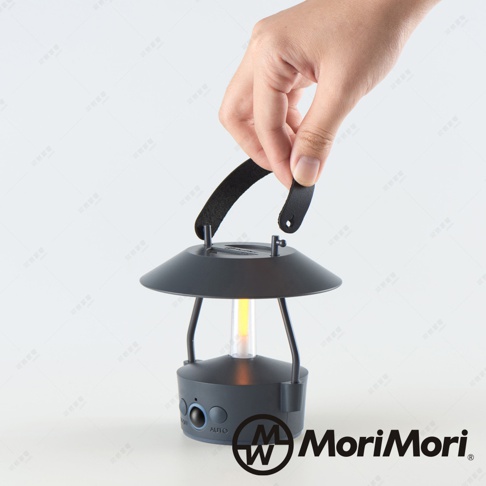 手持黑色皮革提把，展示一個圓形底座、帶有兩個金屬支架的黑色 LED 燈籠，中間是黃色燈芯。