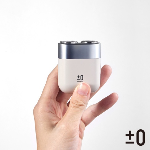 手持白色及銀色便攜式雙刀頭刮鬍刀，右下角有品牌標誌