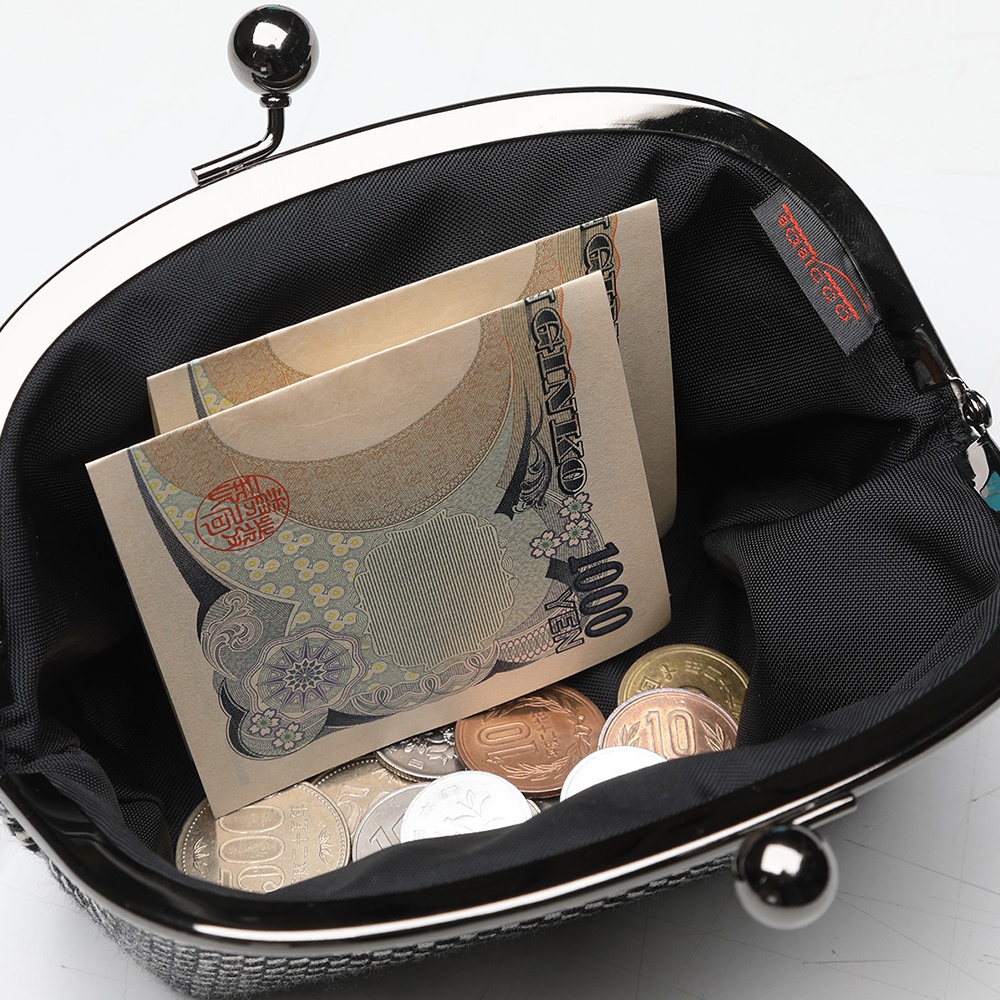 三河木綿刺子織口金零錢包，內有日幣紙鈔與硬幣，零錢包外觀為銀色金屬，內襯為黑色。